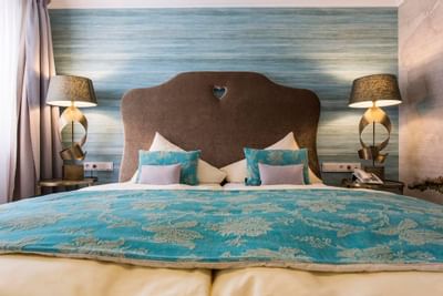 Bed between 2 nightstands in Comfort Suite at Liebes Rot Flueh