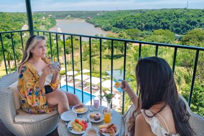 Primer plano de damas disfrutando de un café en el balcón de Panoramic Grand