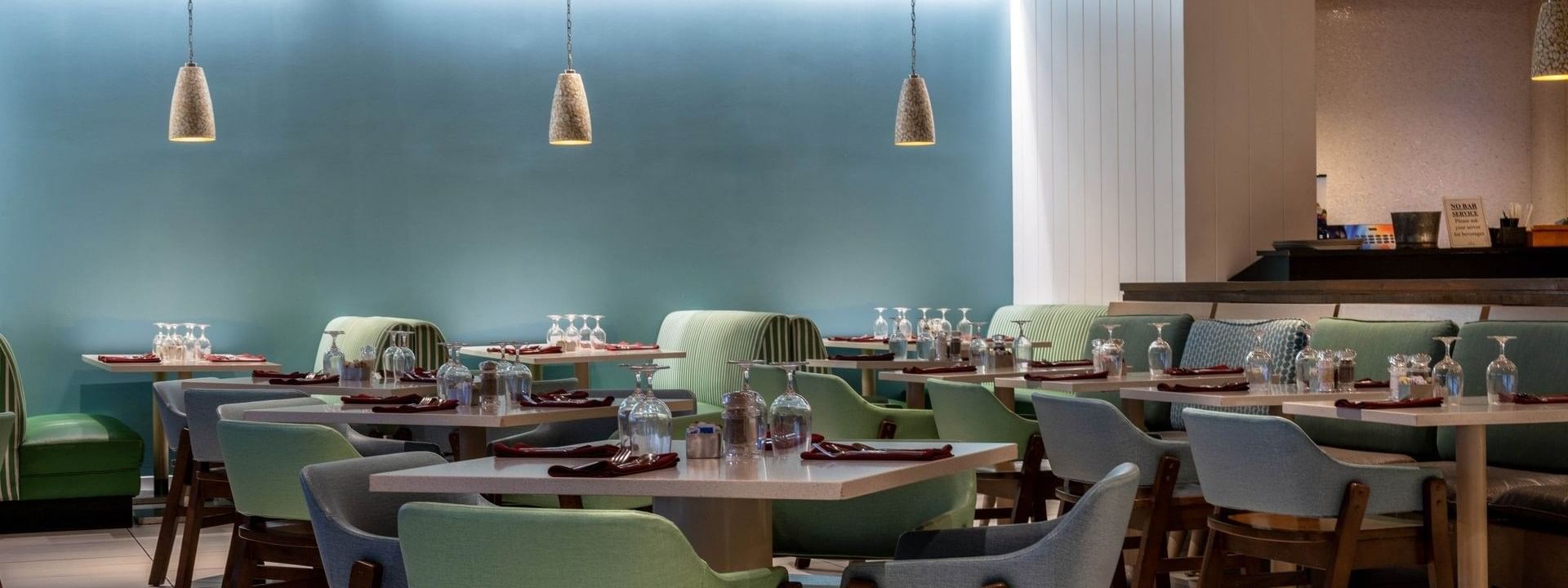 Verandah restaurant interior with green chairs and blue walls at Warwick Paradise Island Bahamas