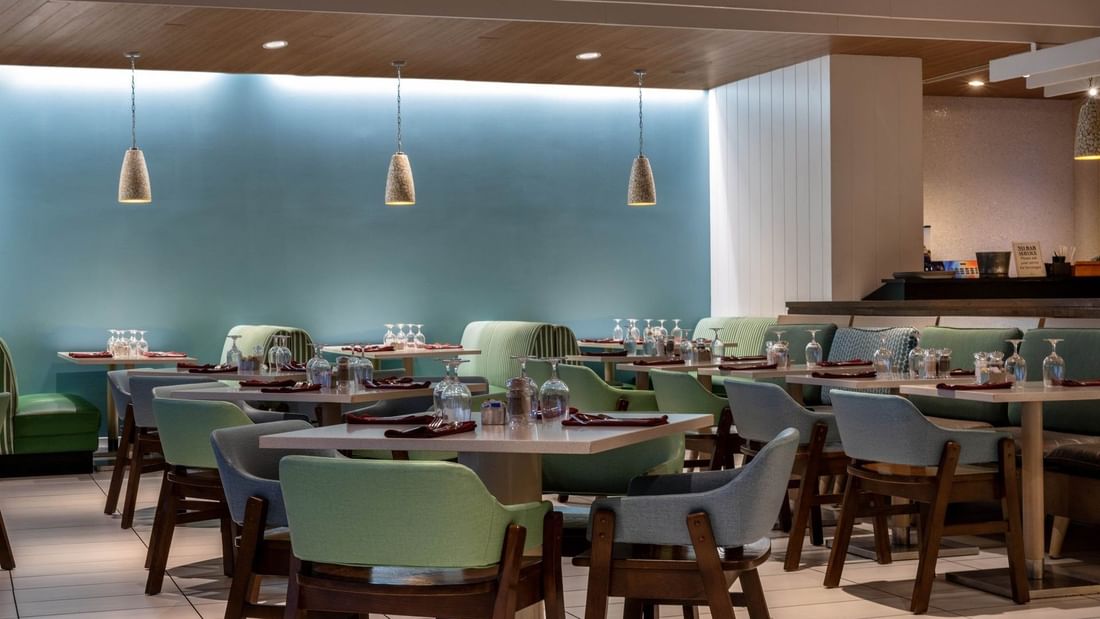 Verandah restaurant interior with green chairs and blue walls at Warwick Paradise Island Bahamas