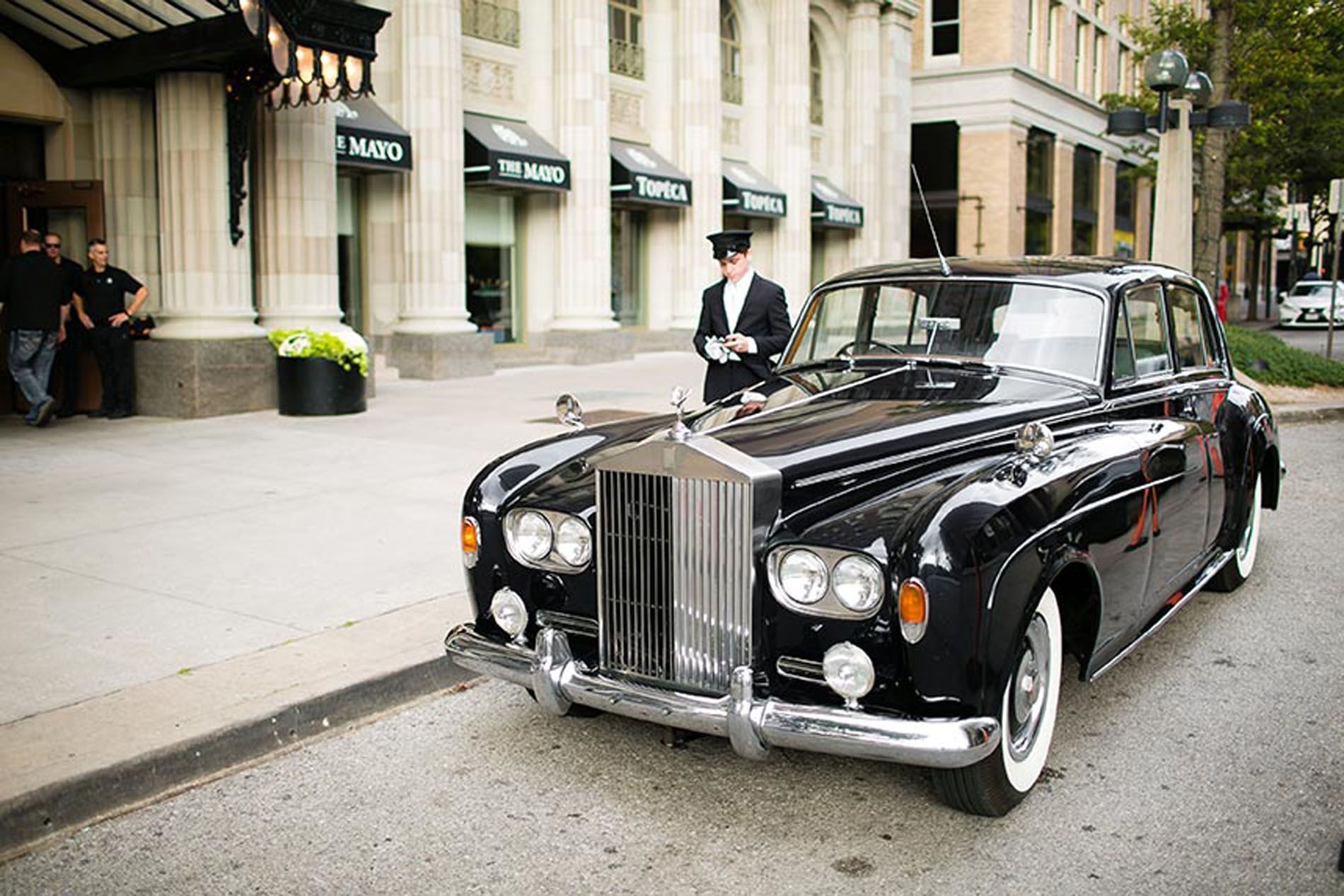 Man with a car standing in front of The Mayo Hotel