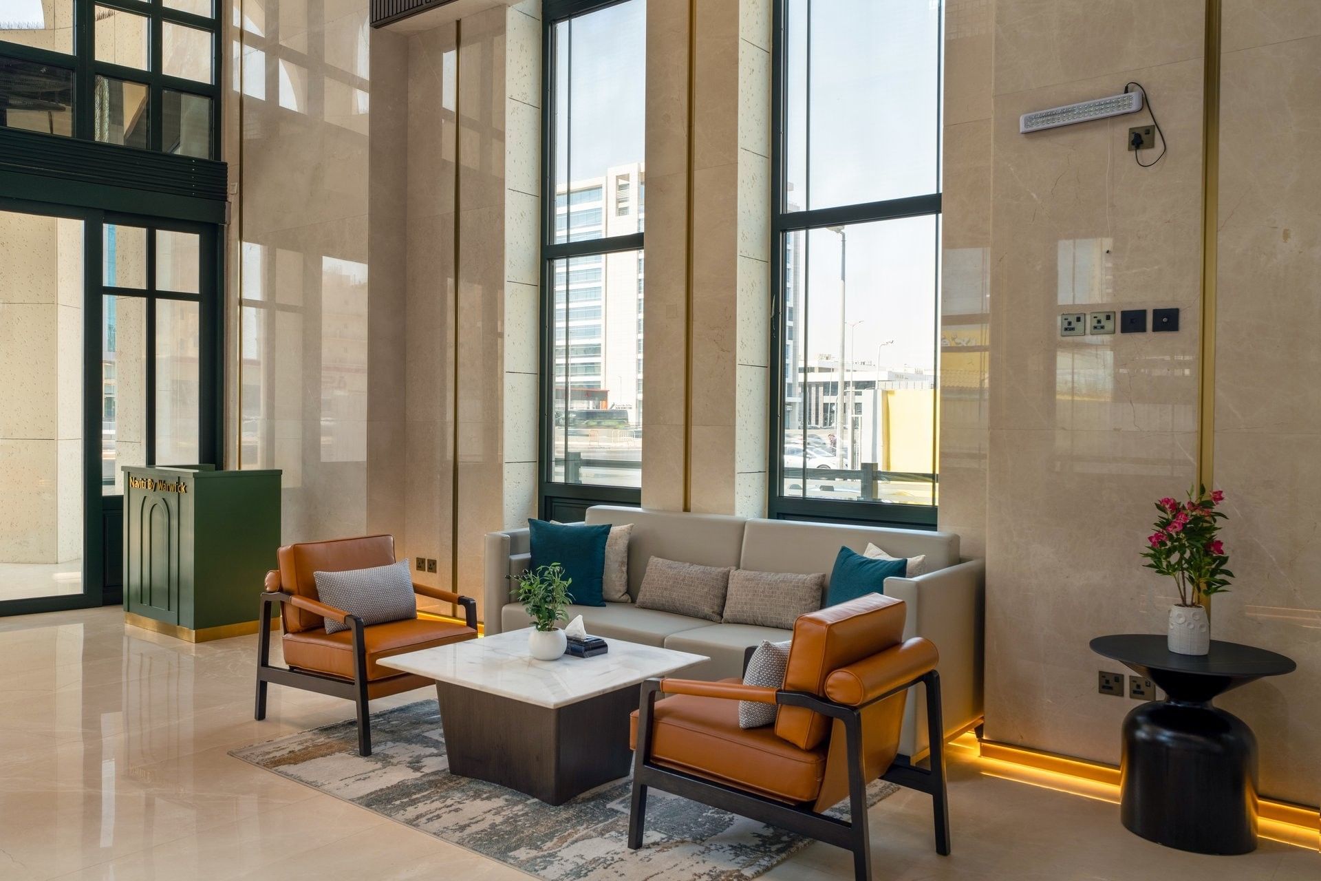 Lobby lounge with armchairs & sofa around marble coffee table at Naviti by Warwick Jeddah, showcasing a luxury boutique stay