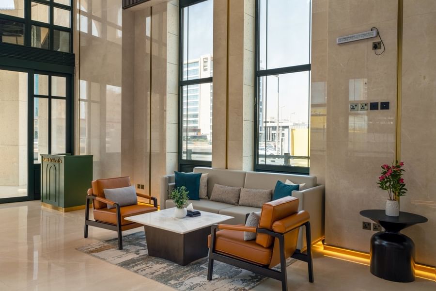 Lobby lounge with armchairs & sofa around marble coffee table at Naviti by Warwick Jeddah, showcasing a luxury boutique stay
