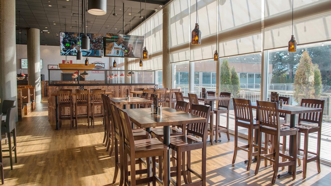 Indoor dining area with wooden tables and chairs under hanging lights.