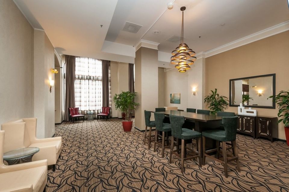 Elegant dining area with a large table and green chairs at Pickwick San Francisco