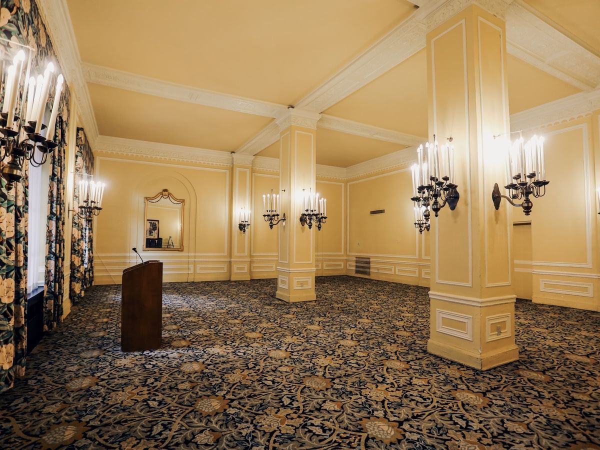 Elegant Magnolia Room featuring floral curtains, patterned carpet and a wooden podium at Arlington Resort Hotel & Spa