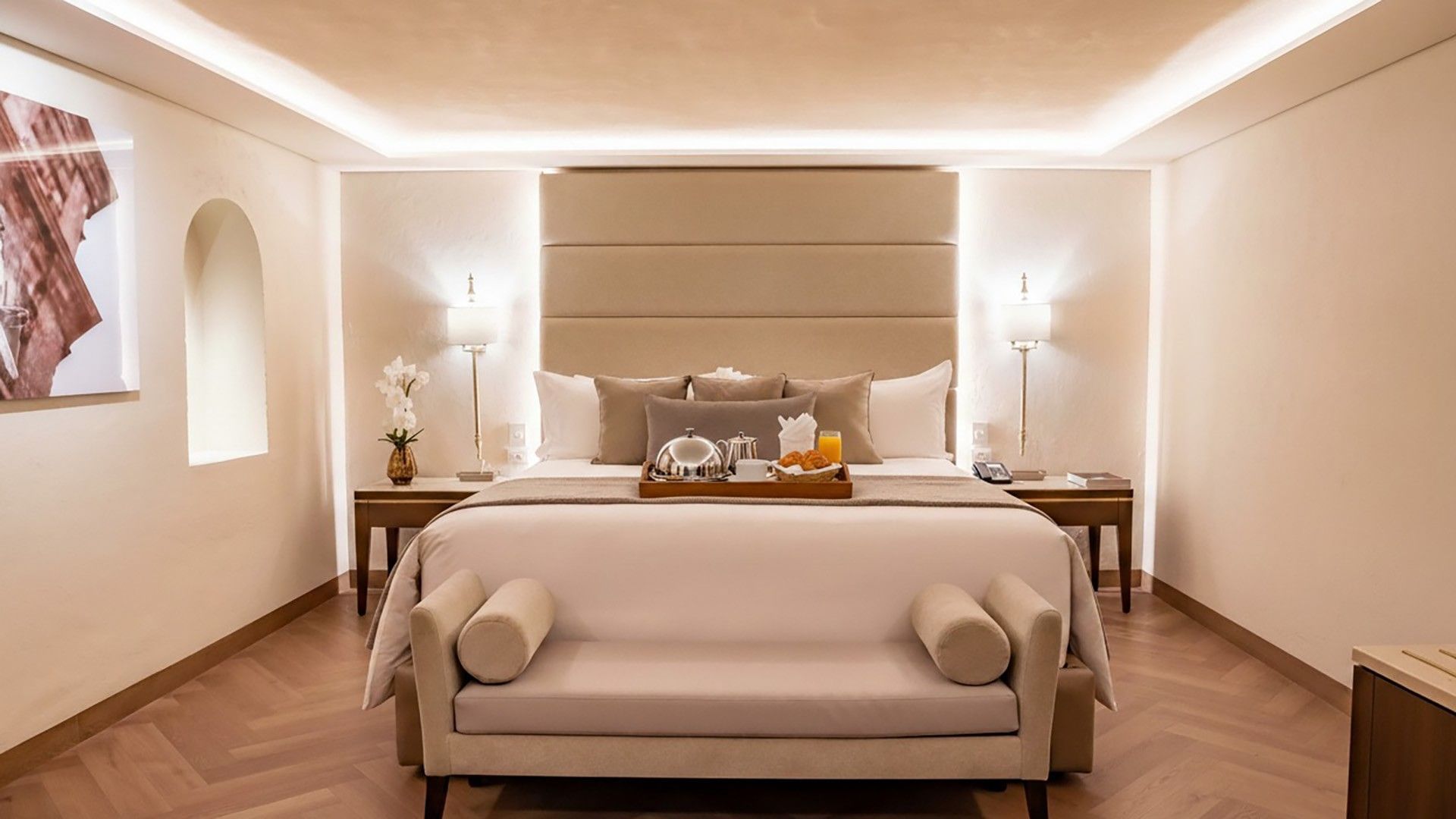 Luxury king bed with a breakfast tray, symmetrical bedside lamps, and a plush bench in King Real at Quinta Real Puebla