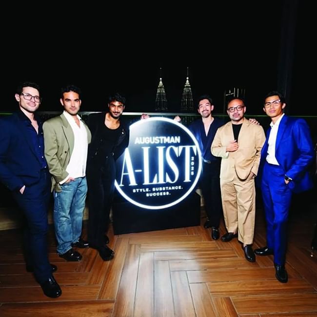 Several men pose in front of the Augustman sign at Imperial Lexis Kuala Lumpur - Lexis Hotels & Resorts