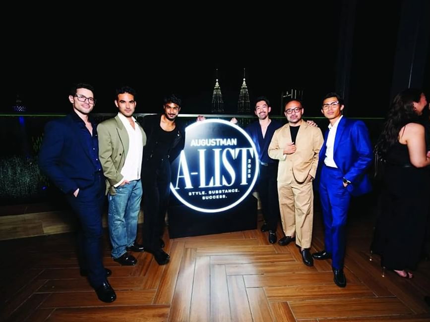 Several men pose in front of the Augustman sign at Imperial Lexis Kuala Lumpur - Lexis Hotels & Resorts
