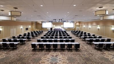 A large corporate event is set up at the Bolger Center Franklin Building with multiple tables, chairs and projector screens