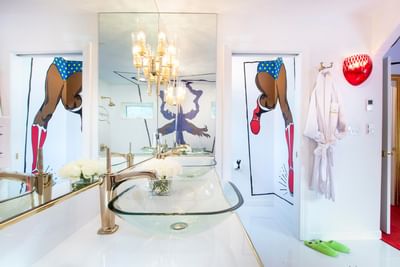 Vibrant bathroom featuring whimsical superhero-themed artwork in The Superhero Incognito at The Roxbury