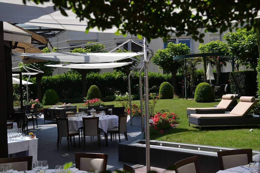The Lounge Bar & Terrace with wicker chairs and tables, shaded by modern awnings at Warwick Reine Astrid - Lyon