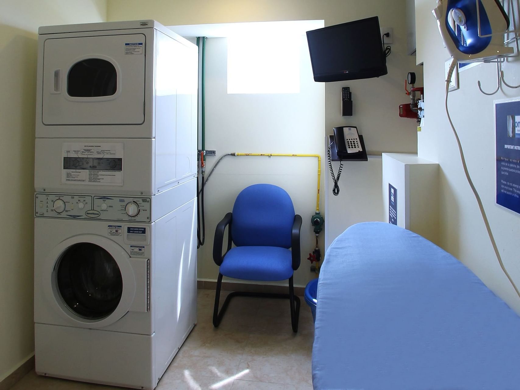 Washing machine, dryer & a chair in Laundry Room at One Hotels