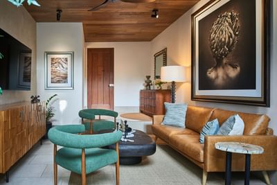 Casa Cielo living area with green chairs, tan sofa, and warm decor, creating a stylish look at Singular Signature Residences