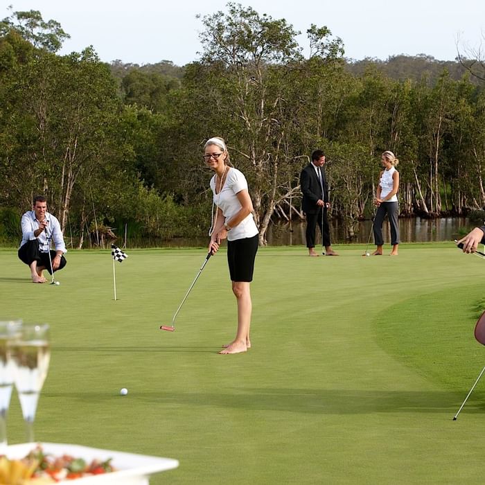 woman playing golf and a man playinh music at Mercure Kooindah Waters