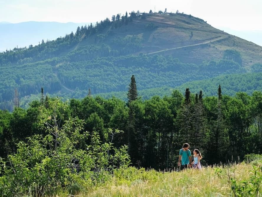 Couple walking on a trail with a mountain in the background near Stein Eriksen Residences