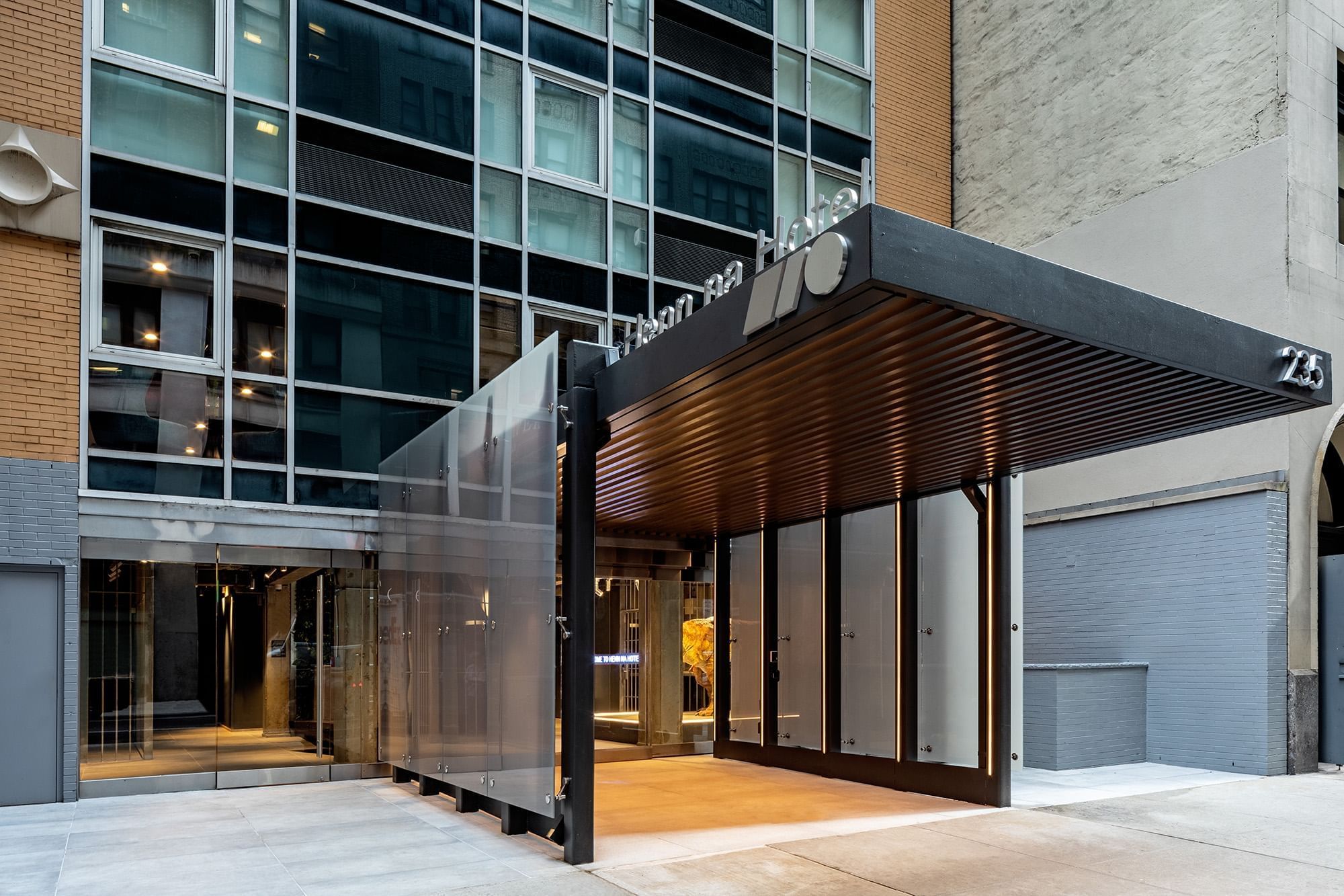 A modern hotel entrance with a glass facade and awning