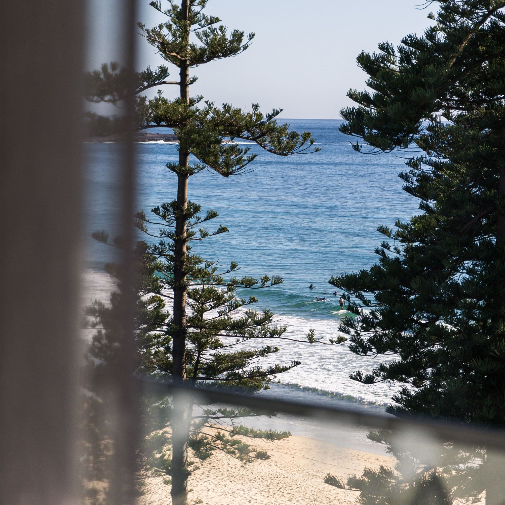Store Beach at Elysium Hotels has a secluded sandy cove with turquoise water and boats surrounded by a dense forest