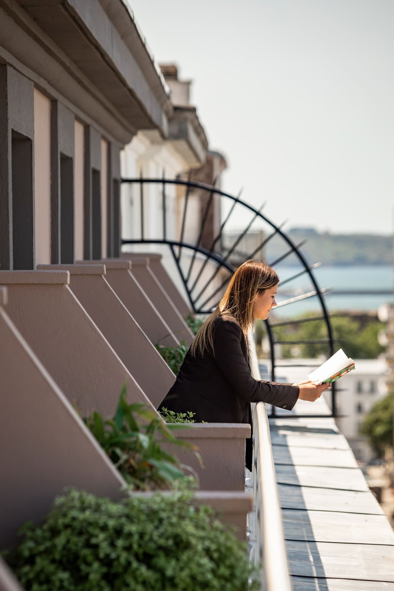 Dame lisant sur un balcon à l'Oceania Le Conti Brest