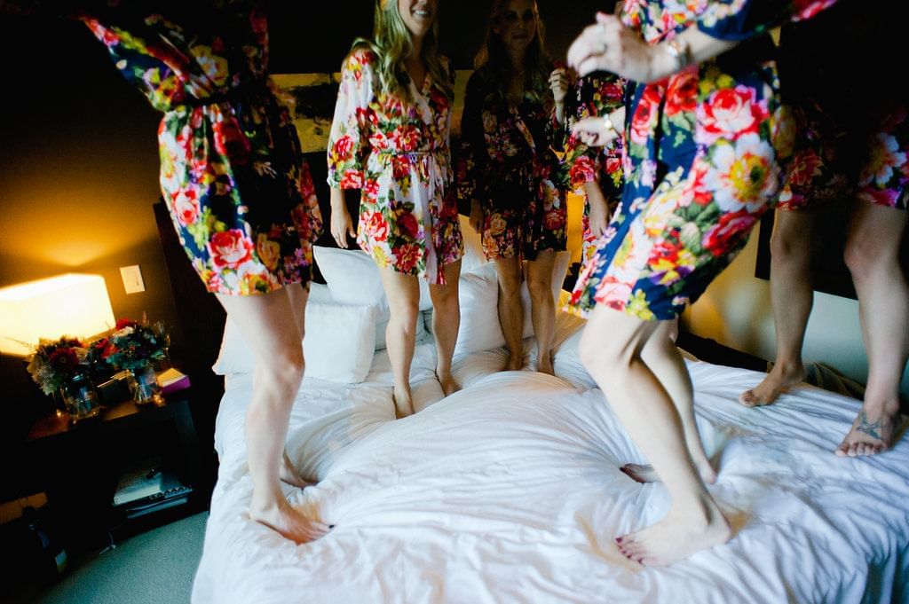 Bride & bridesmaids jumping on the bed at Nita Lake Lodge