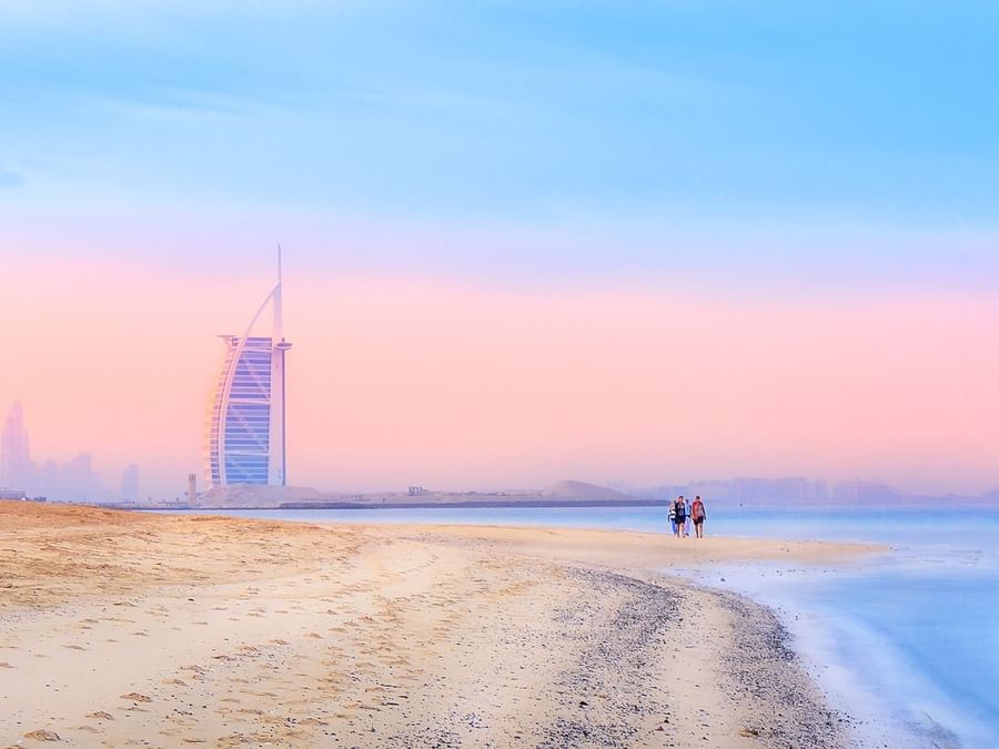 Iconic sail-shaped building by a beach at sunrise near DAMAC Hotels & Resorts, the best family hotels in Dubai