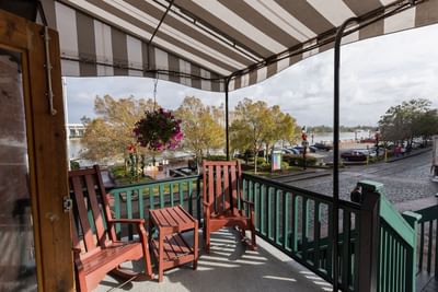 Porch with two chairs and a table, overlooking the carpark at River Street Inn