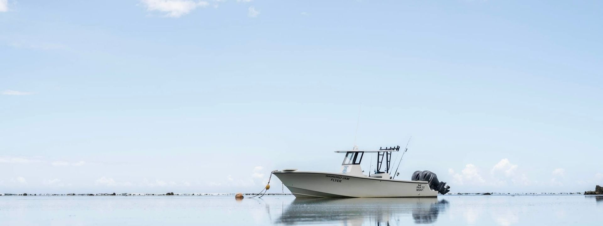 Boat anchored on a serene sea under a blue sky at Warwick Fiji Resort and Spa, Korolevu