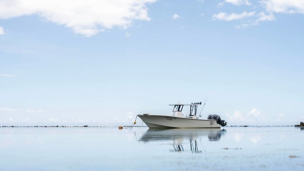Boat anchored on a serene sea under a blue sky at Warwick Fiji Resort and Spa, Korolevu.