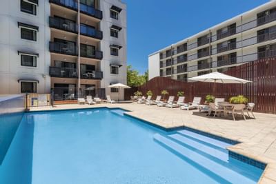 Pool area with canopies & loungers at Nesuto Hotels