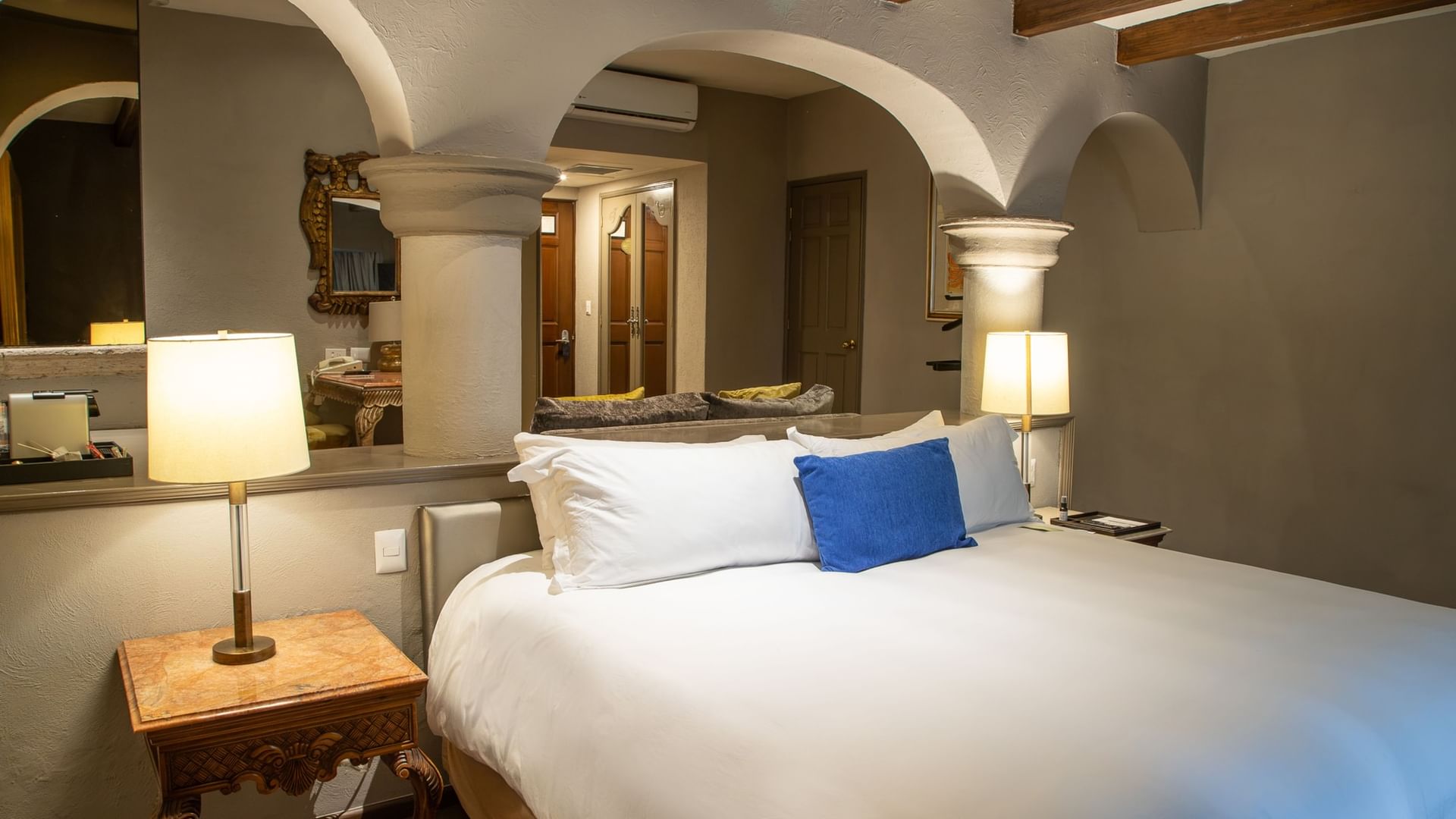 Master Suite King con cama king, arcos coloniales y lámparas de mesa en Quinta Real Guadalajara