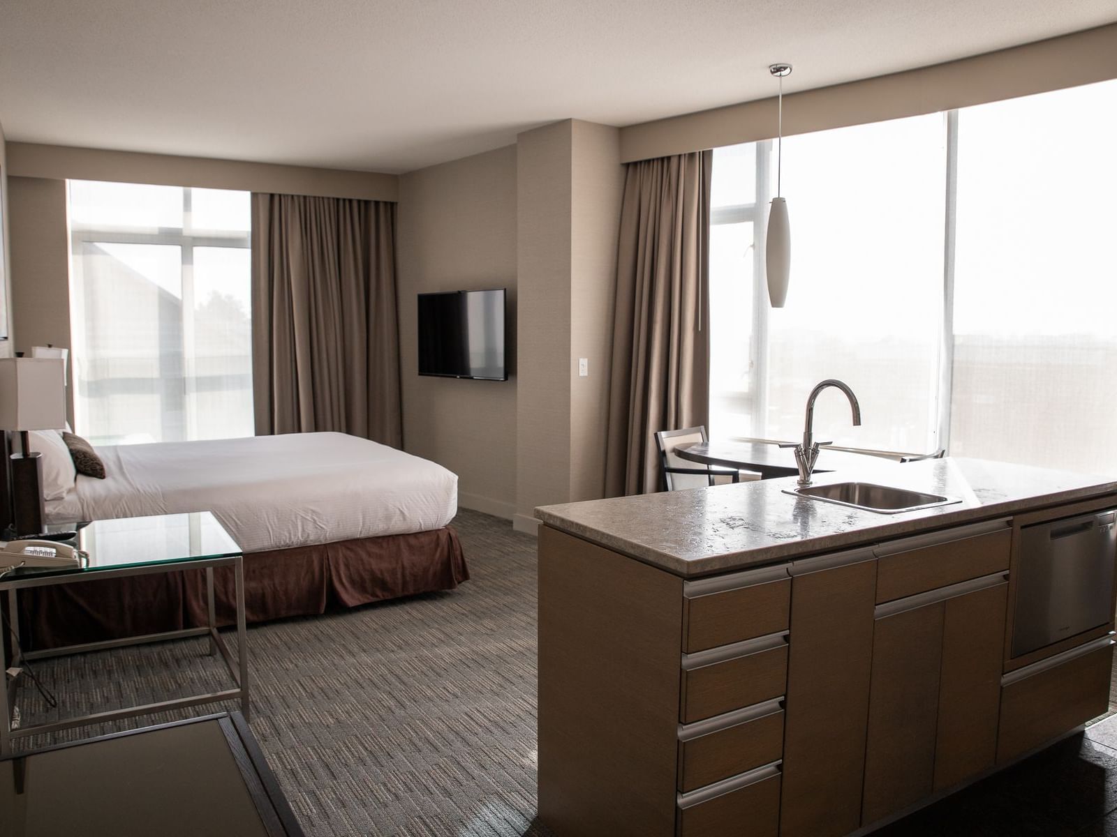 a hotel room with a bed and kitchen area