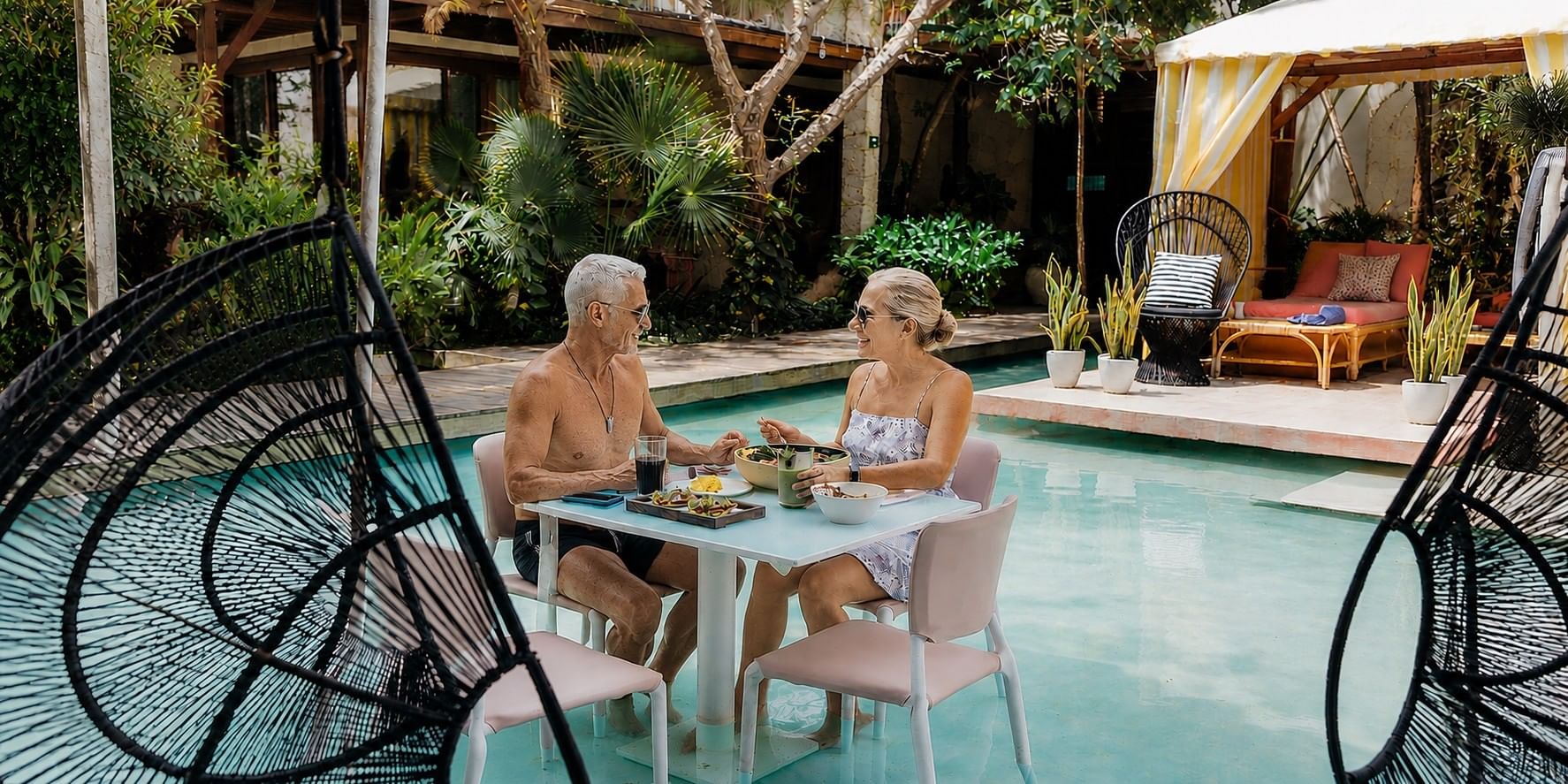 Couple enjoying breakfast beside the pool at Mi Amor Boutique Hotel