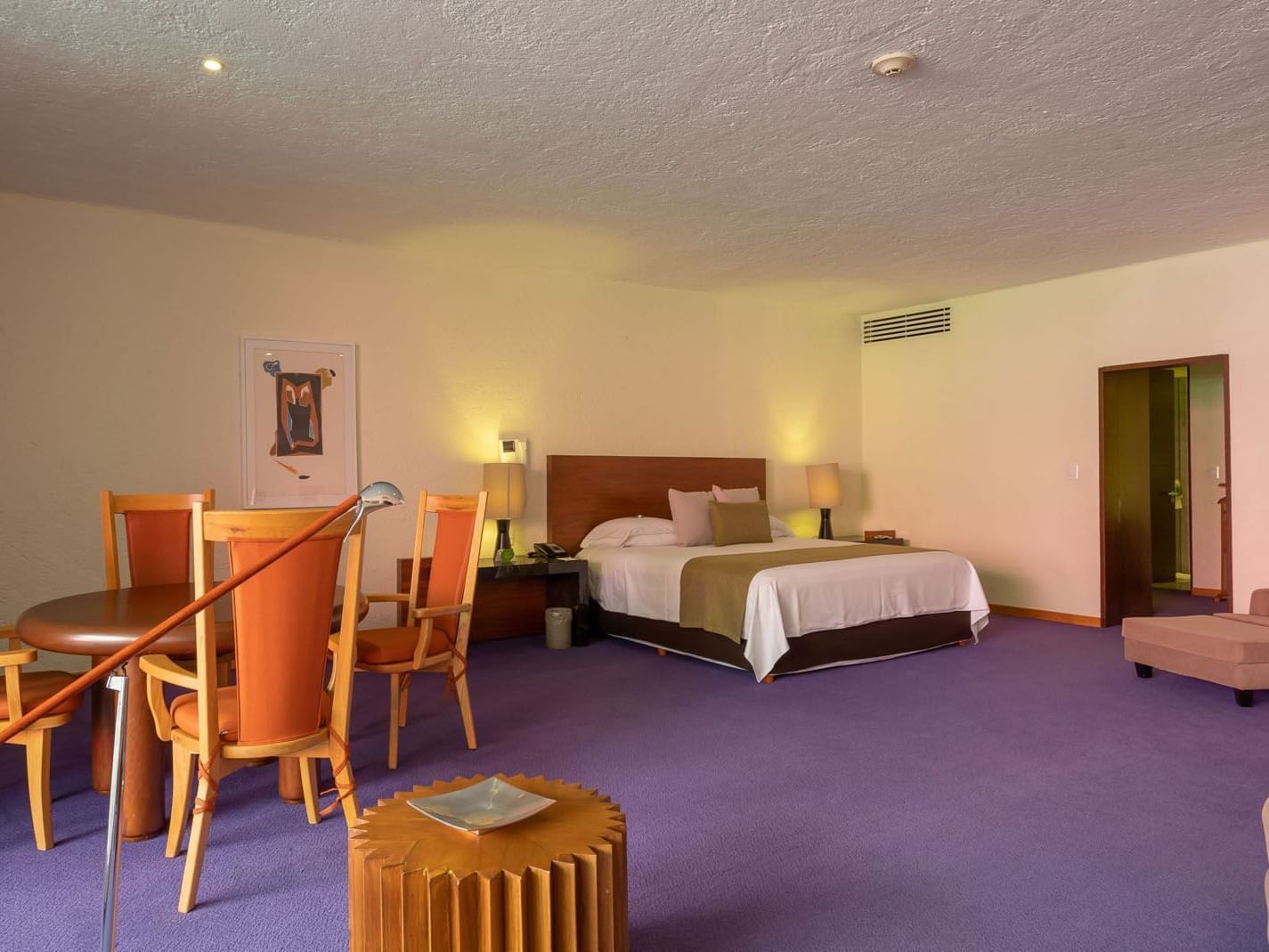 King Fiesta Suite featuring a dining table, purple carpet, and a king-sized bed at Camino Real Polanco Mexico