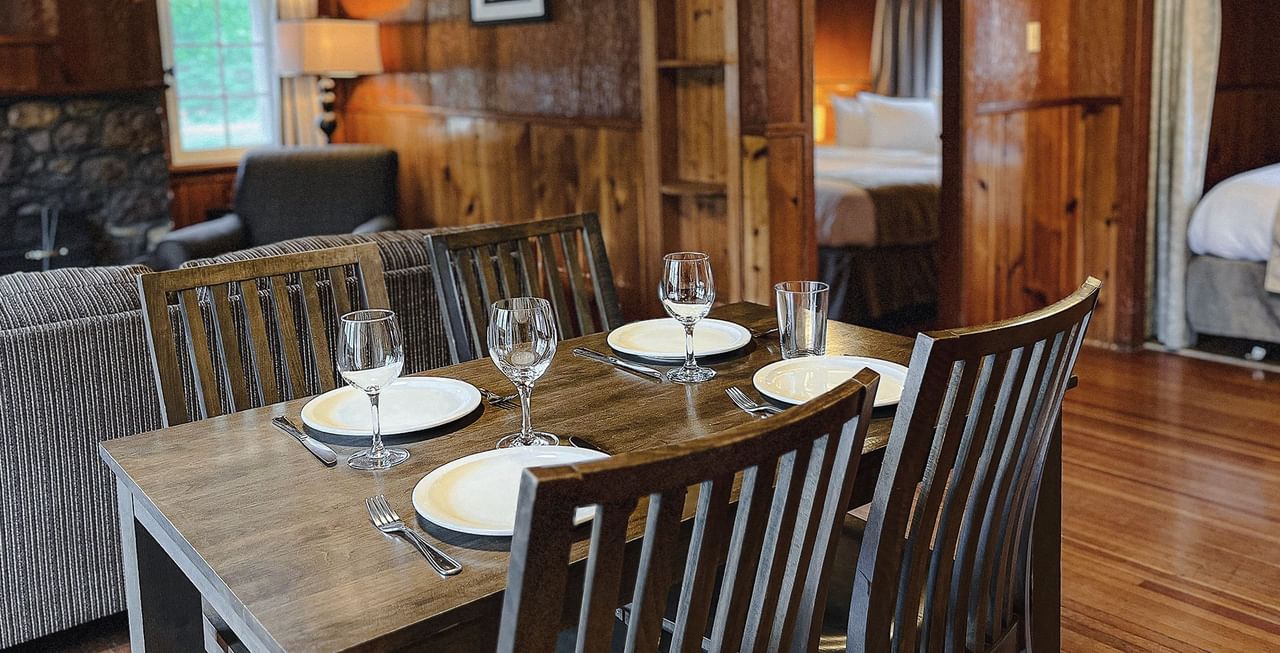 Interior of cabin with dining area, bedroom, sitting area, and fireplace