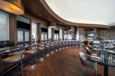 restaurant with dining tables, leather chairs and bar stools