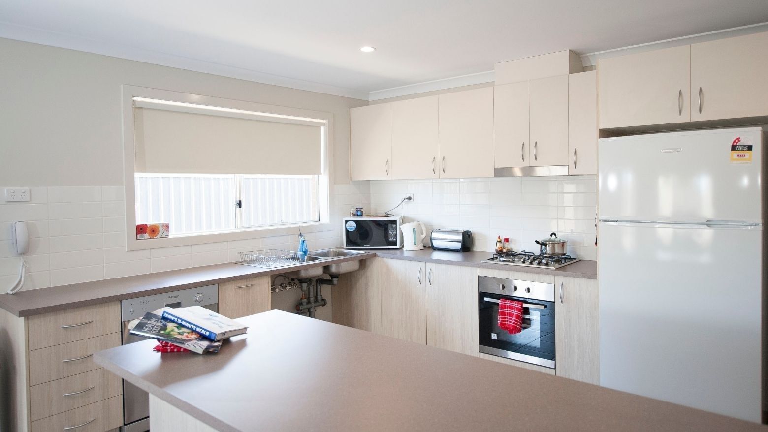 Modern kitchen with white appliances and cabinets at La Trobe University Regional Housing Shepparton.