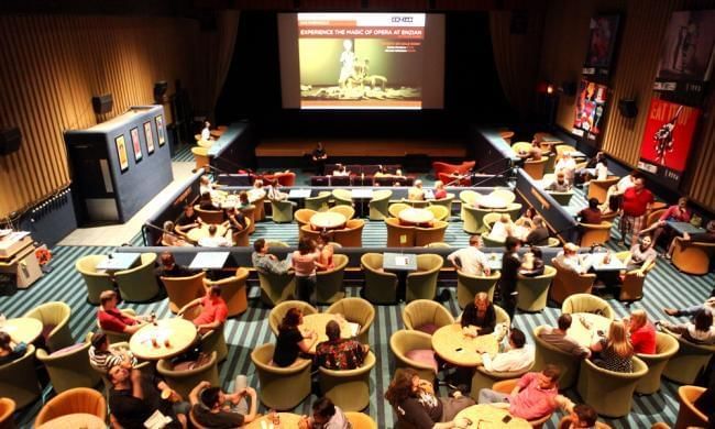 People dining & watching movie at the Enzian near Lake Buena Vista Resort Village & Spa