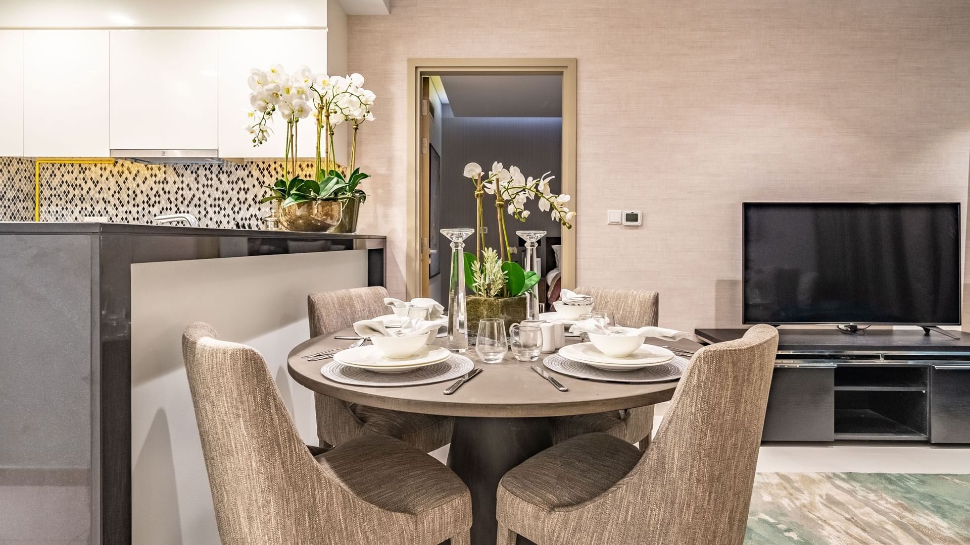 Dining table arranged by the kitchen counter in an Apartment at DAMAC Maison Aykon City Hotel Apartments