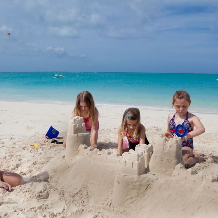 Kids building sand castle near The Somerset on Grace Bay