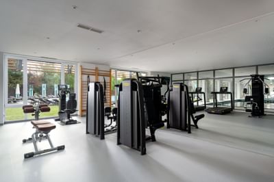 Gym with various workout machines, windows & natural light with a view of an outdoor area at Ana Hotels Europa
