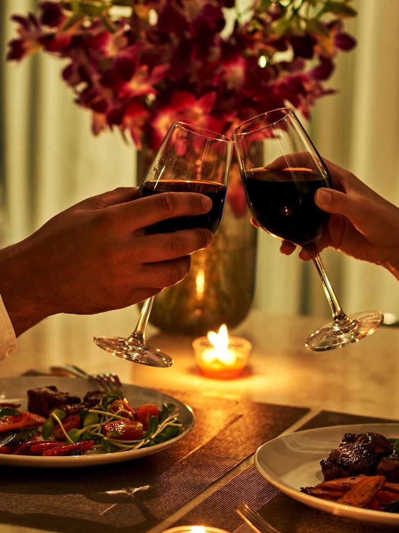 Two guests toasting with wine at a romantic dinner at Warwick Allerton Chicago