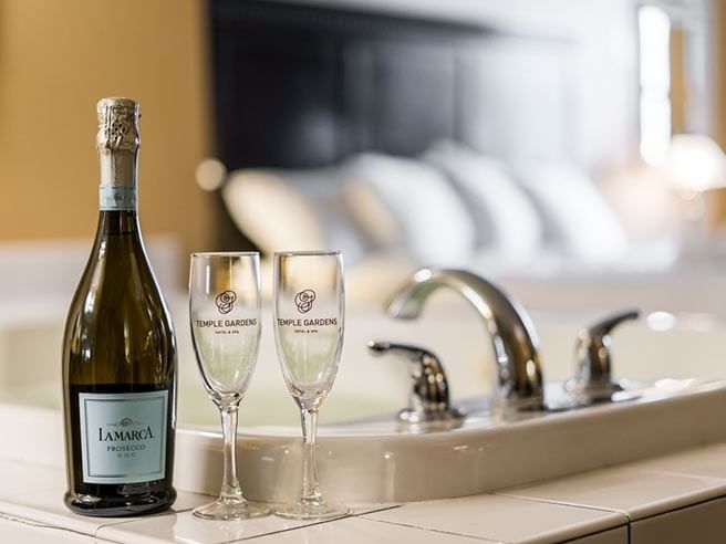 Champagne bottle with two glasses served by bathtub edge at Temple Gardens Hotel & Spa