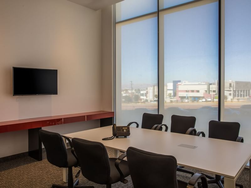 Mesa de conferencias junto a la ventana de una sala de reuniones de One Hotels