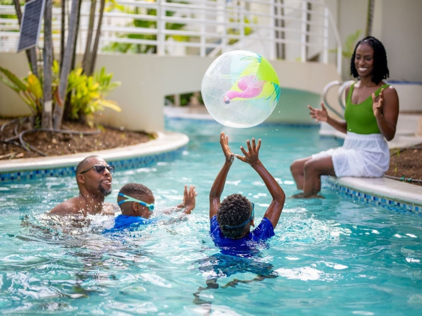 Family having fun with a ball at the pool.