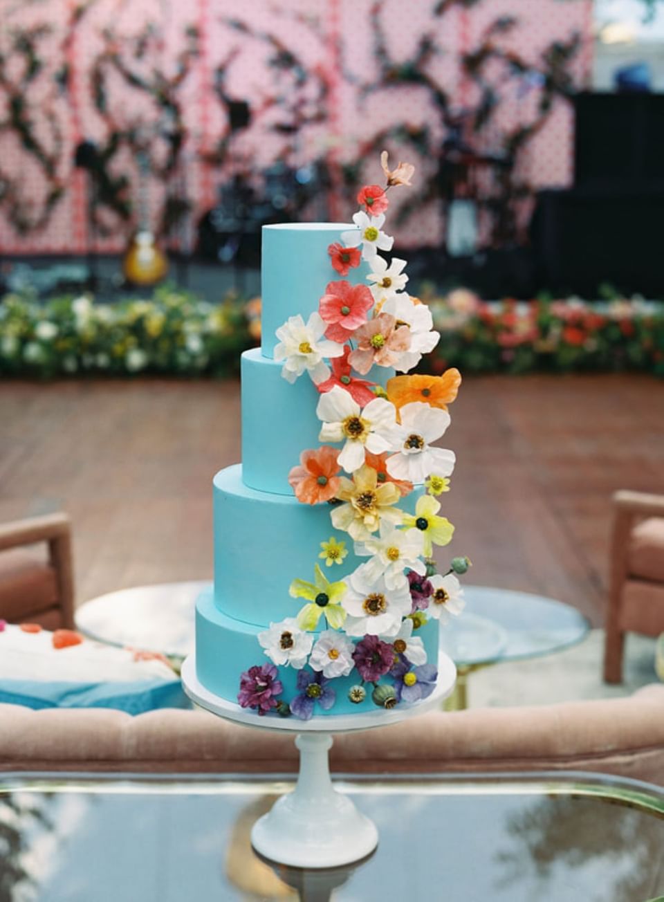 Close-up of a blue wedding cake decorated with colorful icing flowers at The Clifton