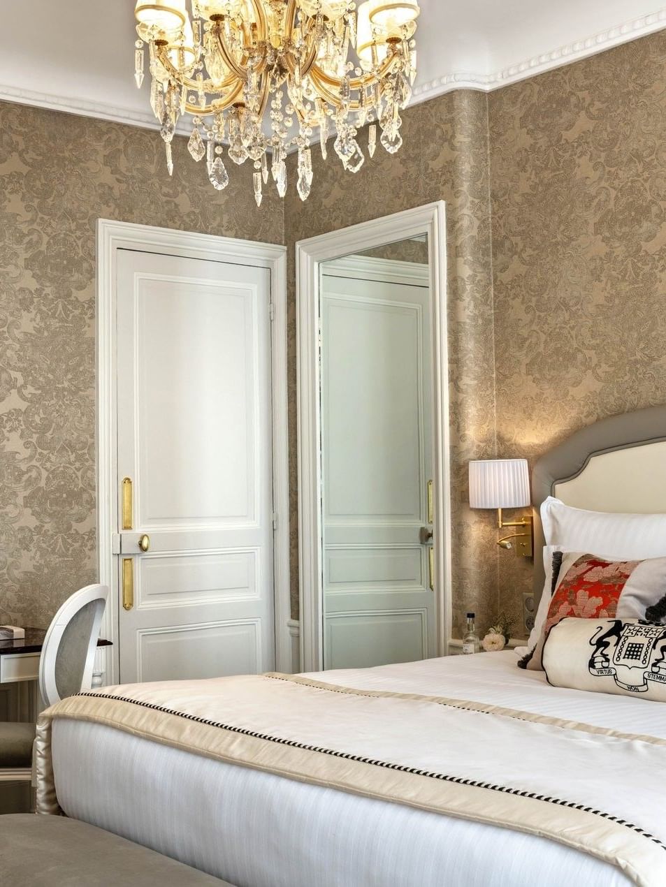 Bed under wall lamp near vanity desk in Prestige Suite – Rue de la Paix View at Hotel Westminster Paris