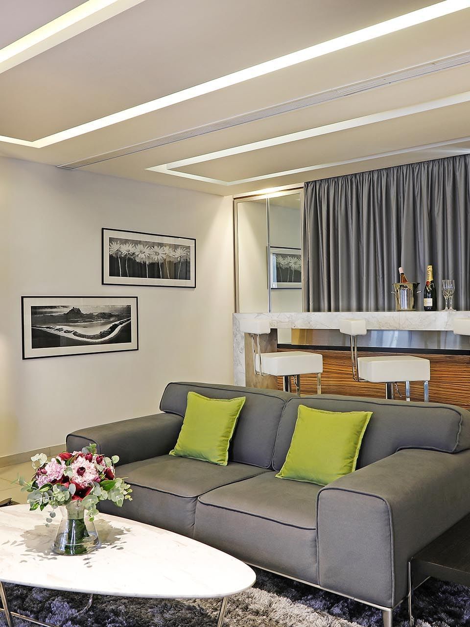 Grey sofa by a marble table and breakfast bar under recessed lights in Executive Suite at Warwick Stone 55 - Beirut