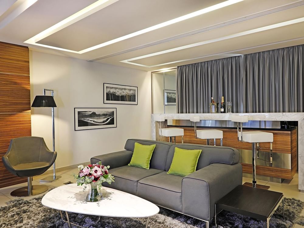 Grey sofa by a marble table and breakfast bar under recessed lights in Executive Suite at Warwick Stone 55 - Beirut