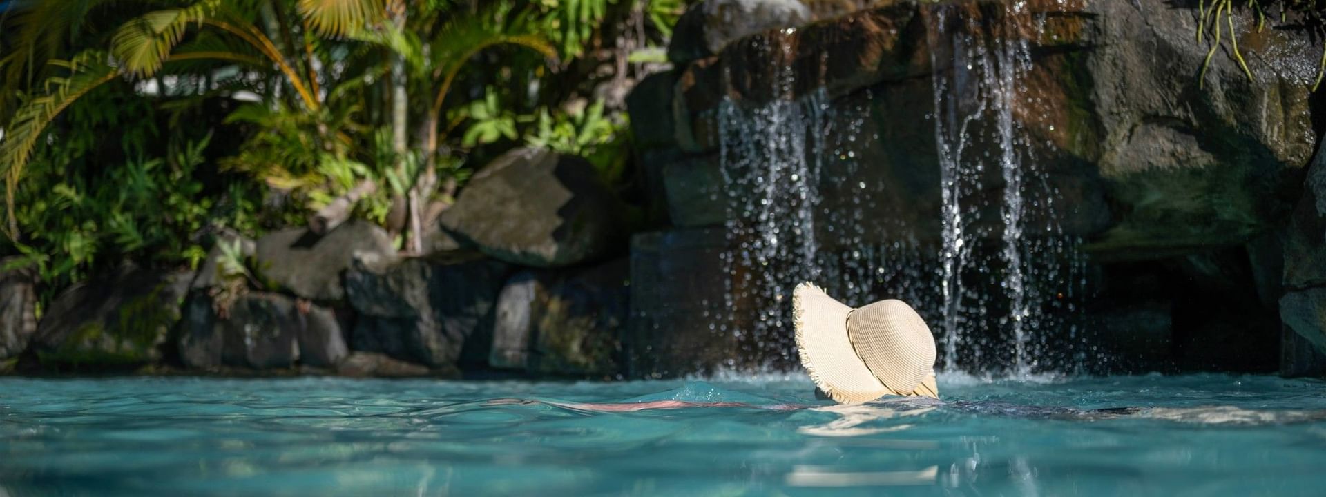 Swimmer relaxing in the pool with a hat at Tokatoka Resort - Fiji International Airport, Nadi