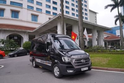 A black van parked in front of a Hanoi Daewoo Hotel